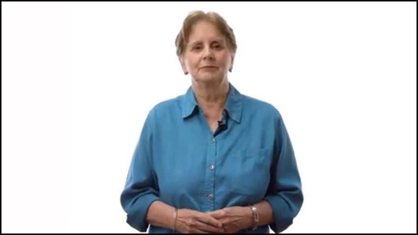 Diane Mathis in a blue shirt, clasping her hands