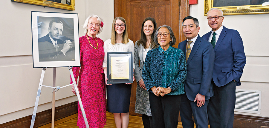 Photo of 6 people posing with picture frame 