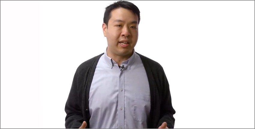Man in front of a plain background looking into the camera.