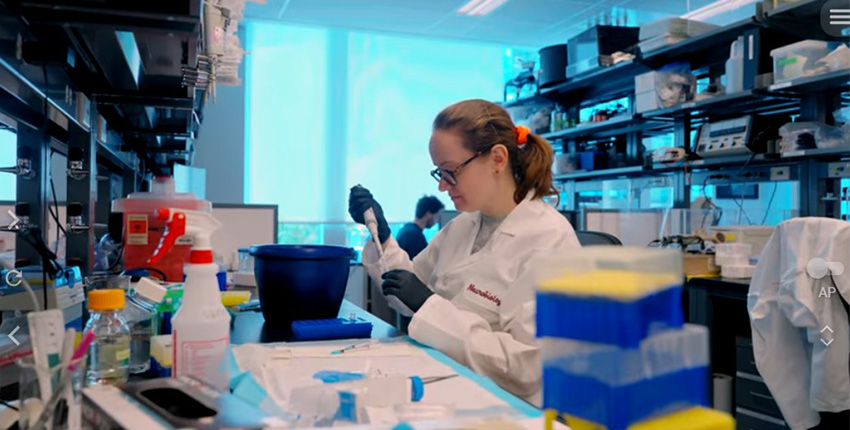 A woman in a white coat pipetting