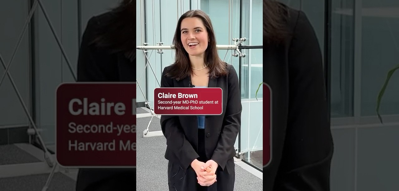 MD-PhD student Claire Brown in a suit with her hands clasped in front of her. 