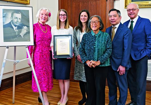 A framed photo of Hollis L. Albright with his daughter, Tenley, and five other people smiling.