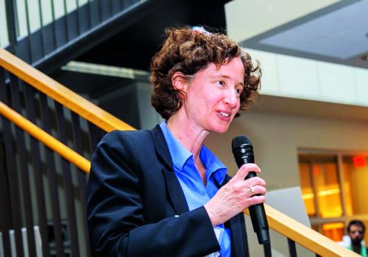 Ifat Rubin-Bejerano speaking into a micrphone.