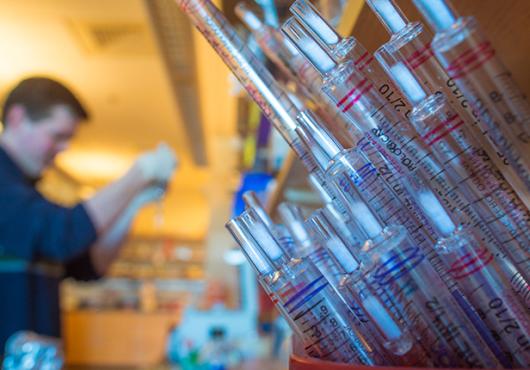 Photo of man with bucket of syringes 