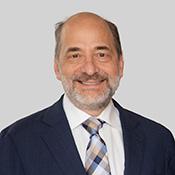 Man wearing a suit smiling.