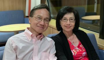 Couple sitting next to each other and smiling.
