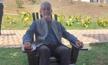 Vikram Patel sits in a chair outside the late Paul Farmer’s apartment at the University of Global Health Equity in Rwanda
