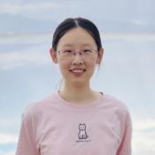 Woman standing in front of clouds.