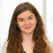 Woman with long, curly hair smiling.