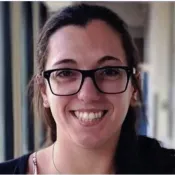 Woman wearing glasses smiling.